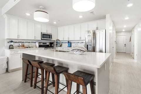 Your sleek kitchen features modern appliances, quartz counters, and a spacious island for cooking and casual dining together.