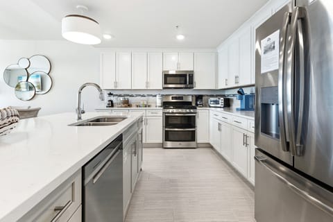 Your sleek kitchen features stainless steel appliances, quartz countertops, and everything needed for culinary adventures.