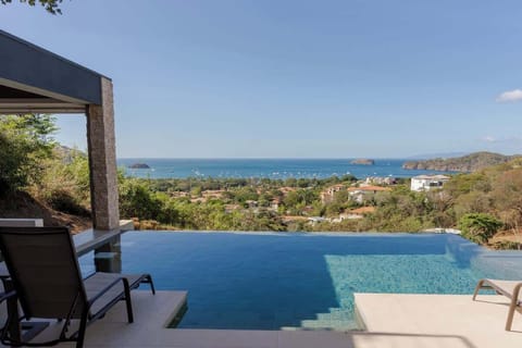 Private pool with lounge chairs and ocean views in a gated community