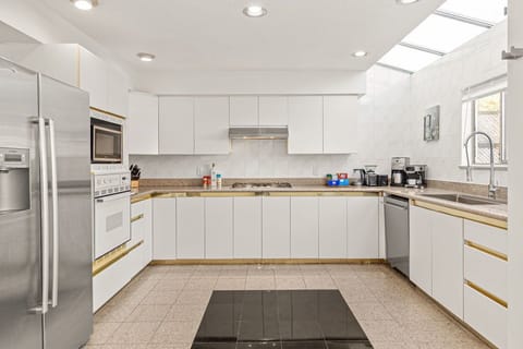 Spacious kitchen with refrigerator, microwave, gas stove, and cooking essentials