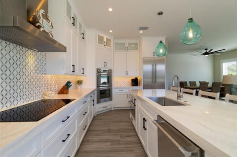 Step into your dream kitchen with gleaming white cabinets, stunning backsplash, and spacious quartz island perfect for cooking memorable meals together.