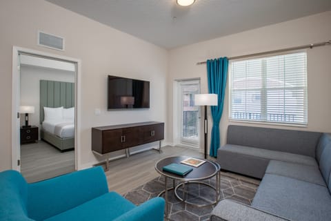 Relax in your spacious living room with plush seating and modern entertainment center, perfectly connected to your private bedroom.