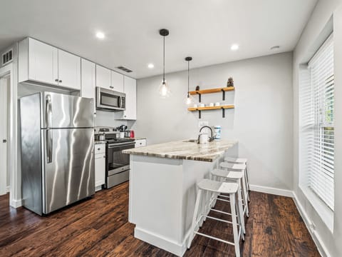 Cook with style in your modern kitchen featuring stainless steel appliances, granite countertops, and a convenient breakfast bar for casual dining.