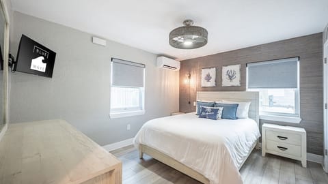 Unwind in crisp linens beneath soft lighting and calm decor