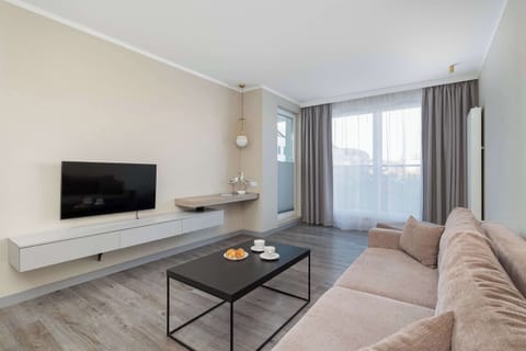 A bright lounge area with a comfortable sofa and TV creates a perfect spot to unwind after a day of sightseeing or work.