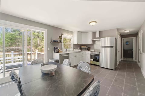 Your fully-equipped kitchen invites morning coffee rituals, with gleaming appliances and a cozy dining nook overlooking peaceful wooded surroundings.