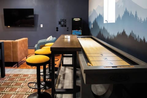 *BRAND NEW* Game room featuring shuffleboard, arcade games, 3 in 1 game table, darts, and lounge seating with smart TV