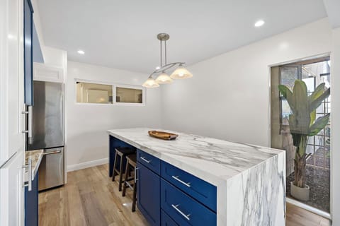 Bright dining area featuring seating for six around a stunning marble kitchen island