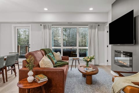 The cozy living room features a sofabed, a flat-screen TV and an electric fireplace.