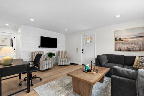 Enjoy this bright living room with comfortable seating, a smart TV, and a dedicated workspace—perfect for relaxing, working, or entertaining with ease.