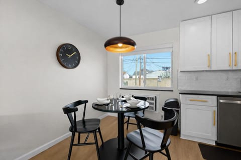 Modern dining nook with stylish seating, warm pendant lighting, and a bright window—perfect for enjoying meals or morning coffee.