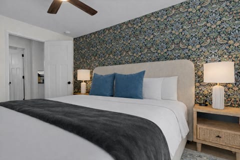 Comfortable, thoughtfully designed bedroom with a plush bed, ceiling fan, soft lighting, and a stylish accent wall for a relaxing retreat.