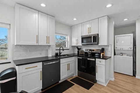Bright, modern kitchen with sleek appliances, ample cabinetry, and in-unit laundryâideal for cooking comfortably and enjoying longer stays.
