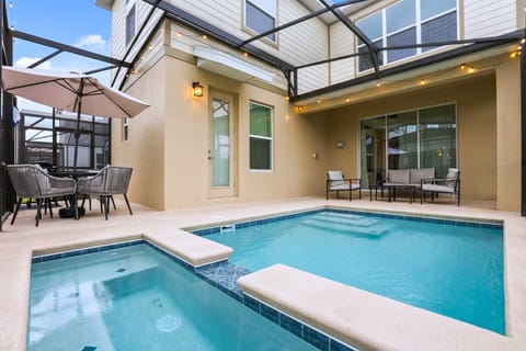 Spacious pool and spa area with shaded outdoor dining and grill, ideal for relaxing days and evening swims