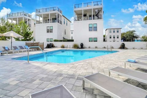 Welcome to The Magnolia by Stay on 30a! Unwind at the large communal pool, offering abundant lounge chairs for your comfort.