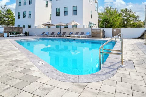 Unwind at the large heated communal pool, offering abundant lounge chairs for your comfort.