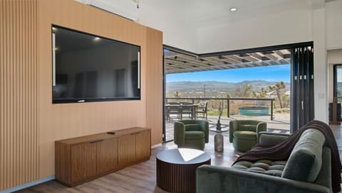 Experience seamless indoor-outdoor living with floor-to-ceiling bi-fold doors opening to breathtaking desert vistas