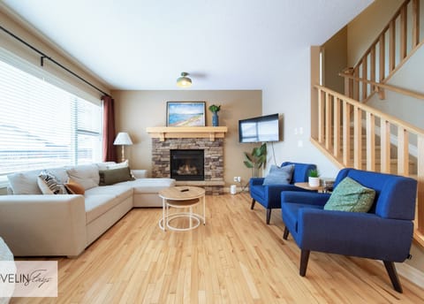 Spacious lounge with sectional sofa, stone fireplace, and smart TV