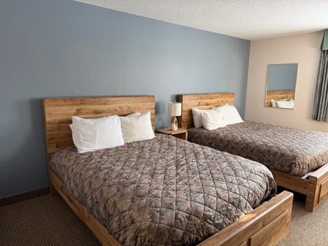 Spacious double queen room offering rustic charm and natural light.