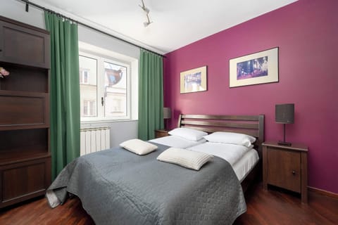 Bedroom with double bed and colorful accent wall.