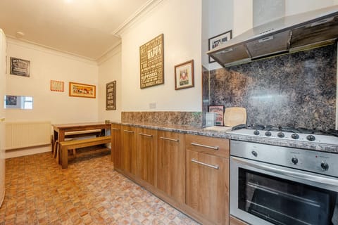 Kitchen view with long worktops, cooker, and a dining bench in the same space