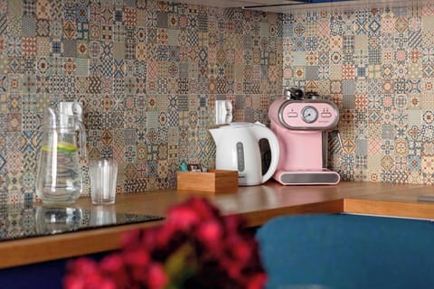 Decorative kitchen detail with coffee machine, countertop accessories, and patterned tiles.