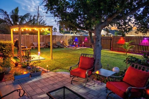 Right out the back door to the secured fenced yard with seating and cool lights.