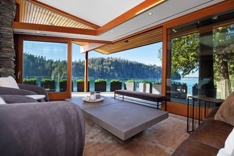 Unwind in your sophisticated living room with stunning lake and forest views through floor-to-ceiling windows.
