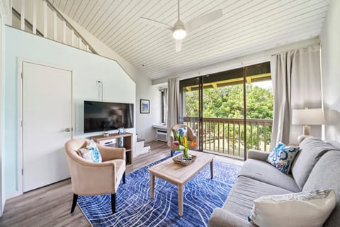 Vaulted ceilings lift the whole living room, with sliding doors framing the green just outside.