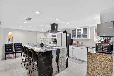An elegant kitchen island with curated bar seating extends the dining experience