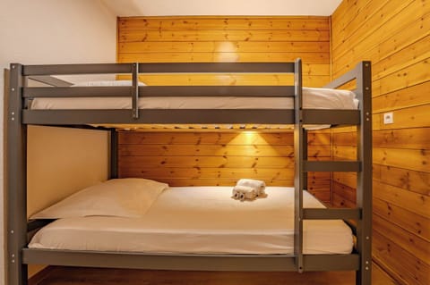 Val Thorens Rue du Soleil ski studio — cozy bunk bedroom for families, sleeps 4, wood-panel alpine style near the slopes.