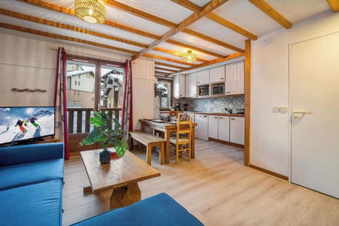 Bright open living area with comfortable sofa and panoramic windows facing the slopes.