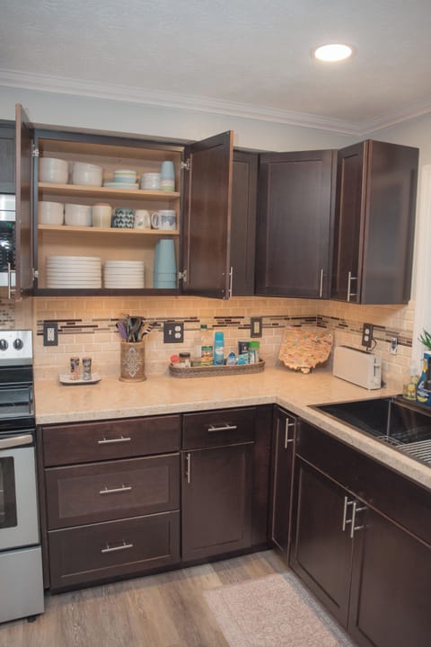 Fully stocked kitchen with dishes, glassware, and cookware ready for use.