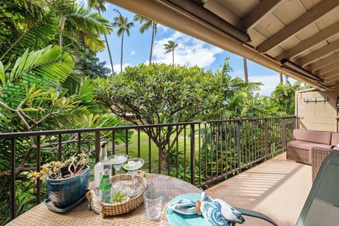 Covered outdoor patio with seating for four, nestled in tropical foliage and ideal for relaxing or entertaining.