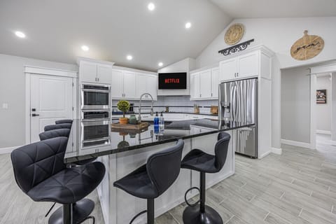 Fully stocked open concept kitchen with bar seating for 6