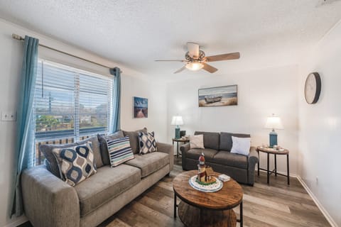 Settle into this cozy living room where soft gray sofas and nautical artwork create your perfect retreat for relaxation.