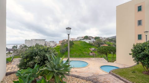 Relax by the shared pool surrounded by lush greenery and ocean glimpses—ideal for unwinding after a day of exploring. #PoolAccess #OceanView #PeacefulRetreat