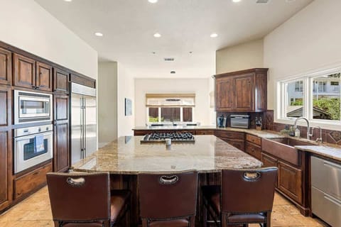 The heart of the home: a gourmet kitchen with warm wood cabinets, granite counters, and stainless steel finishes. Ideal for family dinners, entertaining, or simply enjoying a glass of wine while you cook.