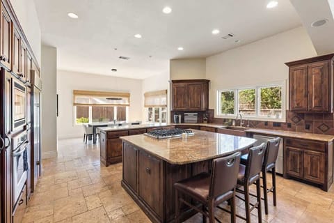 The heart of the home: a gourmet kitchen with warm wood cabinets, granite counters, and stainless steel finishes. Ideal for family dinners, entertaining, or simply enjoying a glass of wine while you cook.