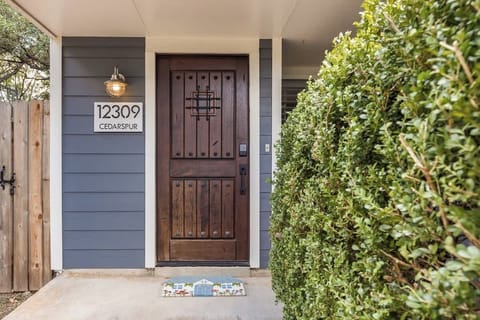 Inviting entrance with soft blue exterior and a rustic Spanish-style door.
