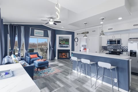 Bright, upscale living room with vaulted ceilings, lake views, and bar seating