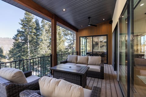 Spacious covered deck featuring comfortable outdoor seating and scenic mountain views. An ideal spot for morning coffee, evening drinks, or simply enjoying the fresh air.