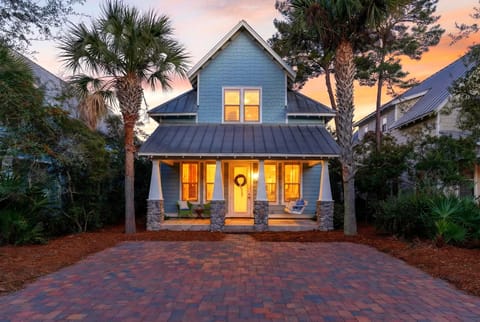 Charming coastal home at dusk with a welcoming front porch.