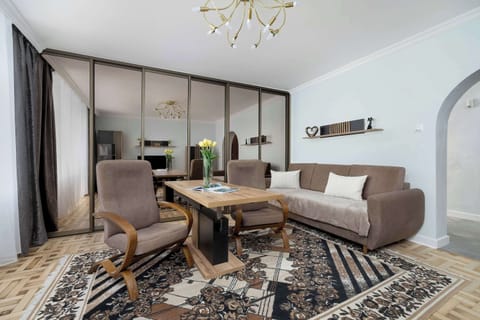 Living room view emphasizing the sofa and dining area. The space is bright and inviting, ideal for relaxing or entertaining.