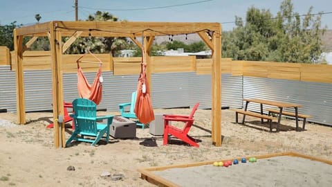 Pergola and Adirondack chairs, picnic table, fire pit, and bocce ball!