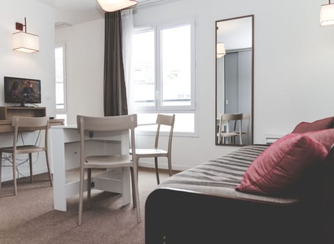 The bright living space combines a sofa bed and dining area for comfortable everyday living.