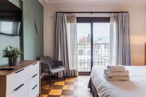 Relax in this bright and cozy bedroom with a private balcony view, perfect for unwinding after a day of exploring.