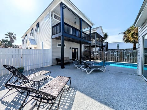 Sunny poolside patio with loungers and shaded balcony