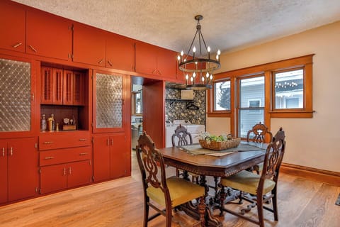 Warm and inviting dining space with vintage charm, featuring rich wood floors, a classic dining table, statement chandelier, and beautiful built-in cabinetry.