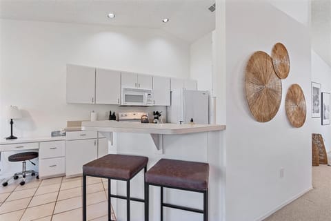 Two stools provide additional seating at the kitchen bar.